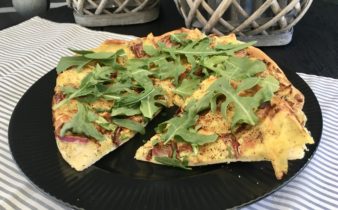 Kartoffel pizza med krydret friskost, rødløg og rucola