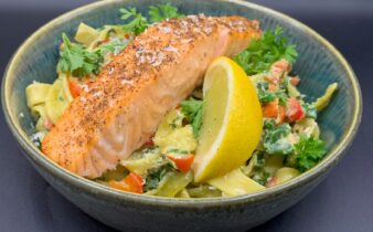 Laks på bund af cremet pasta med spinat, smørstegt peberfrugt, hvidløg og persille