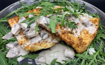 Panko paneret ravioli med spinat og ricotta serveret med mild champignon sauce og rucola